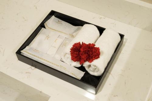 a box with towels and a red flower in it at Muong Thanh Luxury Vientiane Hotel in Vientiane