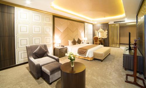 a bedroom with a bed and a couch and a chair at Muong Thanh Luxury Vientiane Hotel in Vientiane