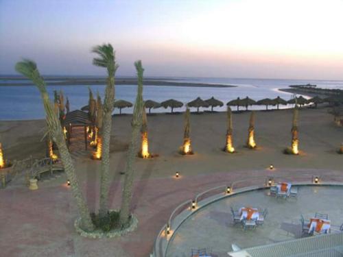 a view of a beach with palm trees and umbrellas at Green Sudr Resort in Ras Sedr