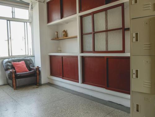 a room with red doors and a chair and a window at Old Man Captain in Tainan