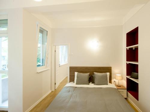- une chambre blanche avec un lit et une fenêtre dans l'établissement Solunska Apartment, à Sofia