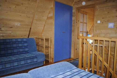 sala de estar con sofá azul y escalera en Domki letniskowe Rafa en Sarbinowo