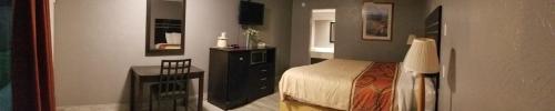 a bedroom with a bed and a fireplace at Executive Inn & Suites Beeville in Beeville