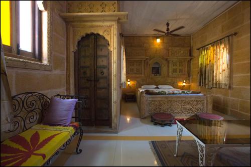 a bedroom with two beds and a table and a couch at The Blue House in Jodhpur