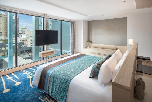 
a hotel room with a bed and a window at Solitaire Bangkok Sukhumvit 11 - SHA Extra Plus in Bangkok
