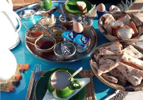 a blue table topped with plates and bowls of food at Maison d'hôtes Dar Farhana in Ouarzazate