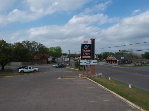 a gas station sign on the side of a road at Executive Inn in Beeville