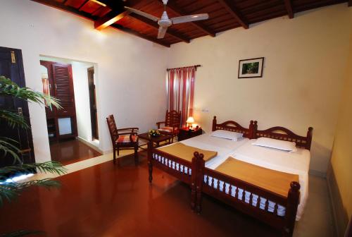 a bedroom with a bed and a table and chairs at Agraharam Resorts in Thirunelli