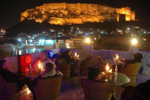 a group of people sitting at tables at night at The Blue House in Jodhpur