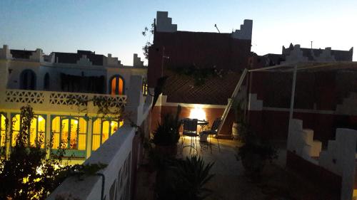 a view of a city at sunset with buildings at Maison d'hôtes Dar Farhana in Ouarzazate