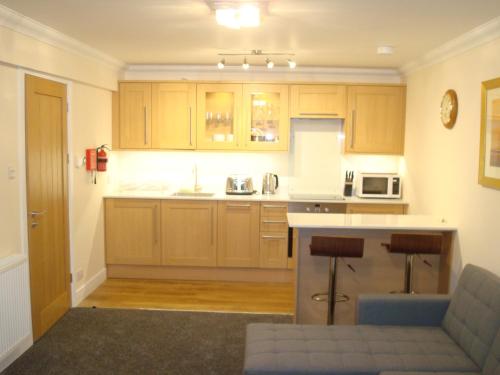 a kitchen with wooden cabinets and a counter top at Glengyle Guest House in Fort William
