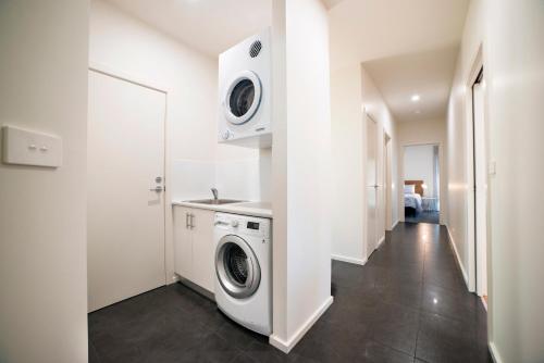 a white laundry room with a washer and dryer at Golton in the Gap in Halls Gap