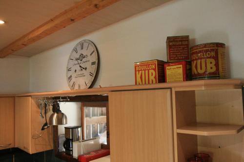 a clock and books on top of a cabinet at grande Cahute in Soultzmatt