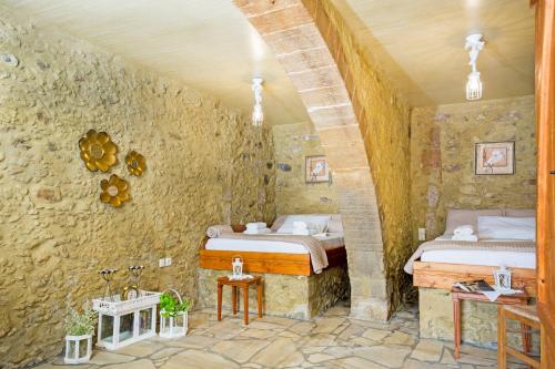 sypialnia z 2 łóżkami w kamiennej ścianie w obiekcie Petrakis Cretan Homes w mieście Kisamos