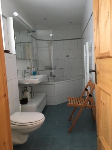 een badkamer met een toilet, een wastafel en een bad bij Haus am Golfplatz in Selfranga