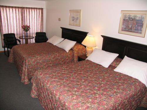 a hotel room with two beds and a table at Seven Oakes Motel in Kingston