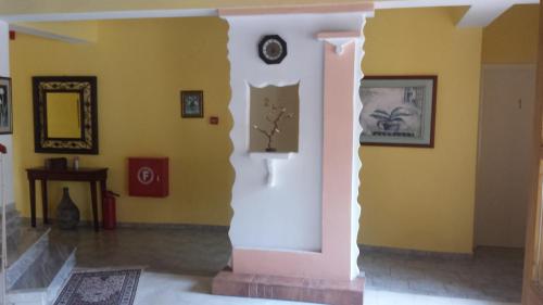 a room with yellow walls and a clock on the wall at Panorama Kakopleyri Kalabakas in Kakoplévrion