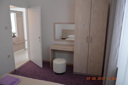 een slaapkamer met een spiegel en een bureau met een kruk bij Apartment Daniela in Lun