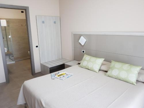 - une chambre avec un lit blanc et un livre dans l'établissement Hotel Francesco, à Padenghe sul Garda