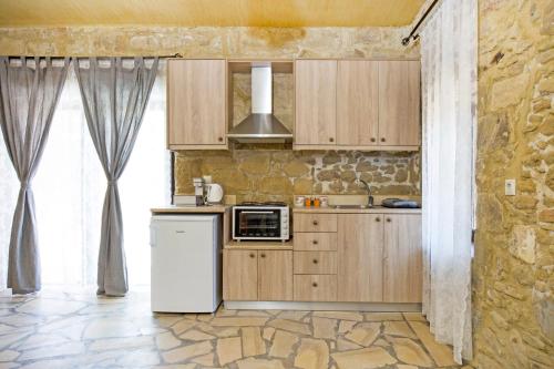 a kitchen with wooden cabinets and a refrigerator at Petrakis Cretan Homes in Kissamos