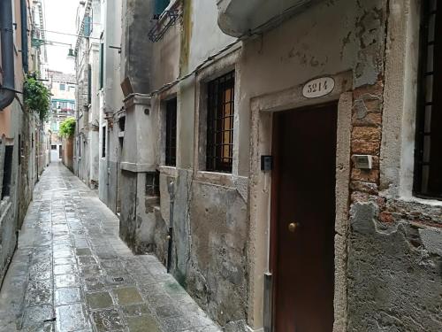 un callejón con una puerta en un edificio antiguo en Calle della Pietà, en Venecia