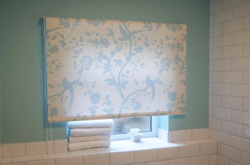 a bathroom with a window with a shower curtain at Conwy Cottage in Conwy