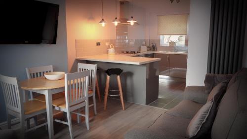a kitchen and living room with a table and a couch at Conwy Cottage in Conwy