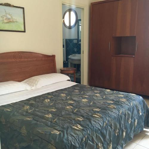 a bedroom with a large bed and a wooden door at La Conchiglia in Sperlonga