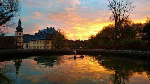 a person swimming in a pond in front of a castle at Pension Weinig in Gersfeld