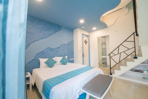 1 dormitorio con 1 cama con una pintura en la pared en Sapphire Inn, en Magong