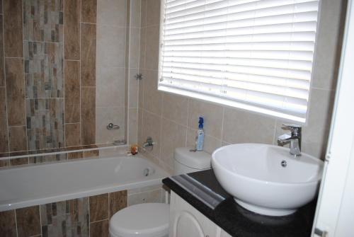 un bagno con lavandino, vasca e WC di 11 Coral Sands a Scottburgh