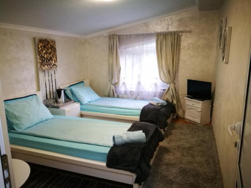 a bedroom with two beds and a tv in it at Hotel Paradise in Sofia