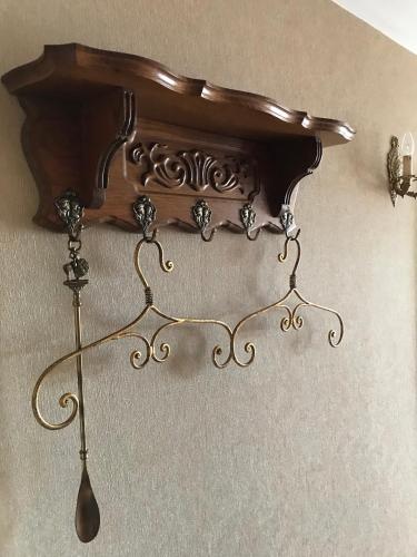 a wooden shelf with a spoon hanging from it at Arbatinės apartamentai in Biržai