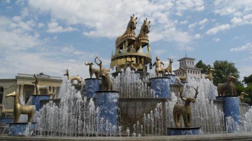 a fountain with deer statues in front of a building at Hotel City Kutaisi in Kutaisi