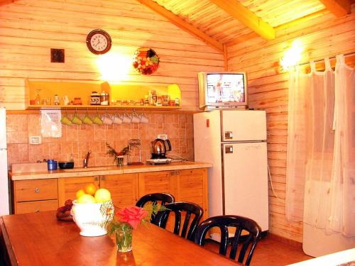a kitchen with a table and a white refrigerator at Hadar Bakfar in Yesod Hamaala
