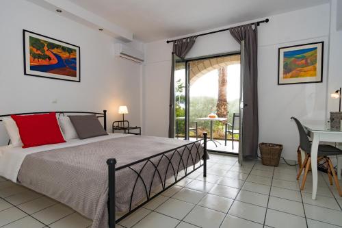 a bedroom with a bed and a table and a window at Olympia Zervea Studios with Pool - Apartment in Kardamili