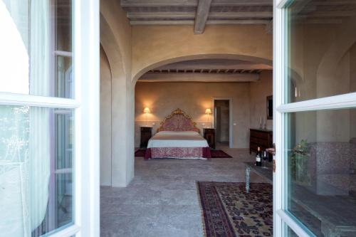 a bedroom with a bed in a large room at Casanova di Neri Relais in Montalcino