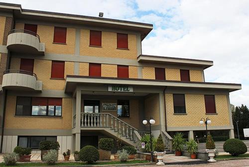 um grande edifício de tijolos com um alpendre e uma varanda em Hotel il Focolare em Fabro