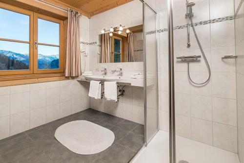 a bathroom with a shower and a sink and a mirror at Bauerndörfl Hüttschlag in Hüttschlag