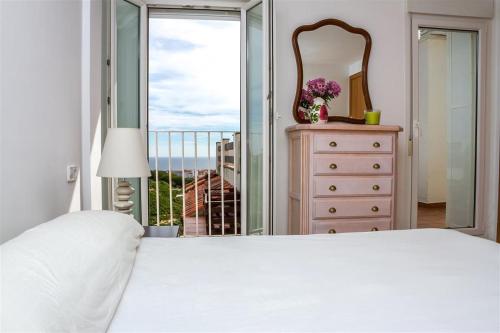 マニルバにあるDúplex vistas al mar en La Duquesaのベッドルーム1室(ベッド1台、鏡、窓付)
