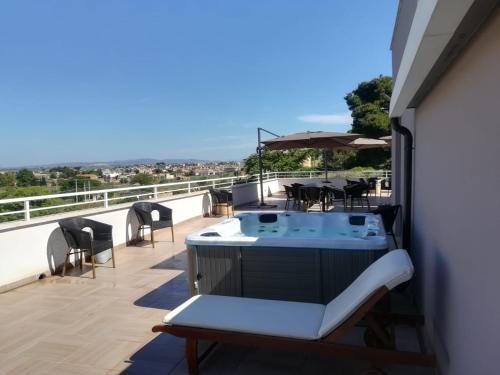 a balcony with a hot tub and tables and chairs at La Terrazza di Harmakhis in Partanna