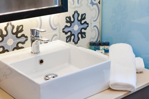 a bathroom with a white sink and a mirror at Remis Studios in Rethymno Town
