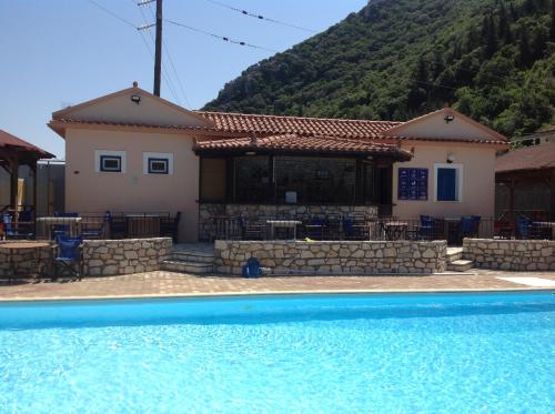 a house with a swimming pool in front of a house at Hotel Nostos in Frikes