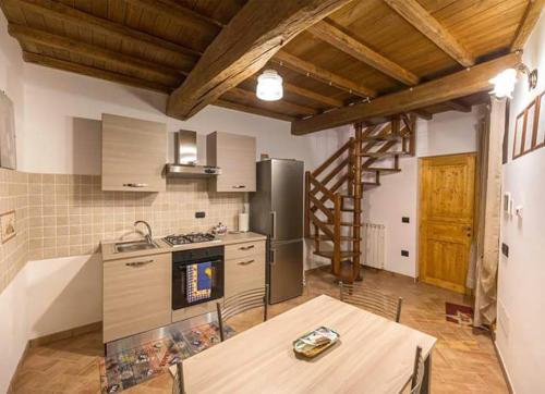 Una cocina con una mesa y un refrigerador de acero inoxidable. en L'Angoletto dei Calanchi, en San Michele in Teverina