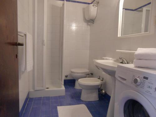 a bathroom with a toilet sink and a washing machine at Ammiraglio in Campese