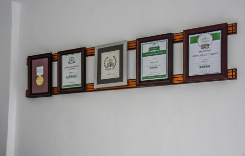 a shelf with framed pictures on a wall at Elegant Hotel in Kandy