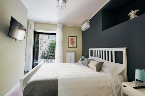 a bedroom with a large white bed and a window at Corte dei medici - Palace in Catania