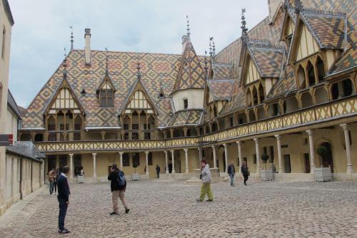 a group of people walking around a large building at la Grange de Félicie in Charrey-sur-Saône