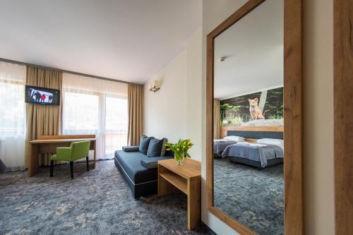 een hotelkamer met een bed en een spiegel bij Góral Spa&Wellness in Szczyrk