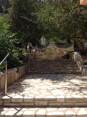 a set of stairs with a table and an umbrella at Hotel Nostos in Frikes